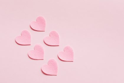 heart shaped papers on pink background